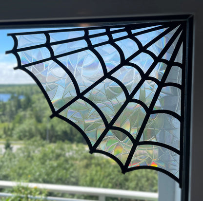 Spiderweb suncatcher sticker applied to a window, showing intricate design